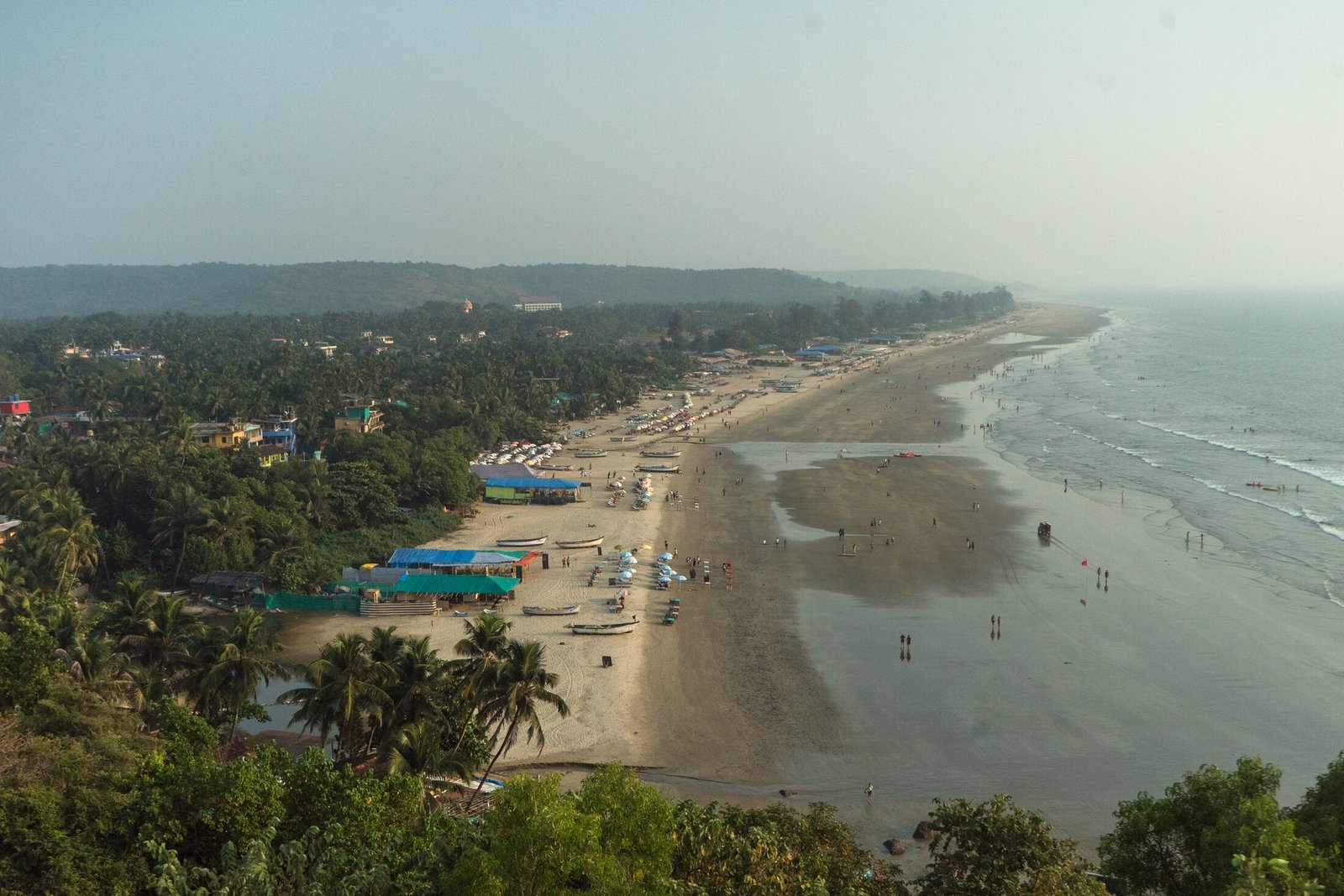 The lively coastline of Arambol Beach sweeping along North Goa in the golden afternoon light