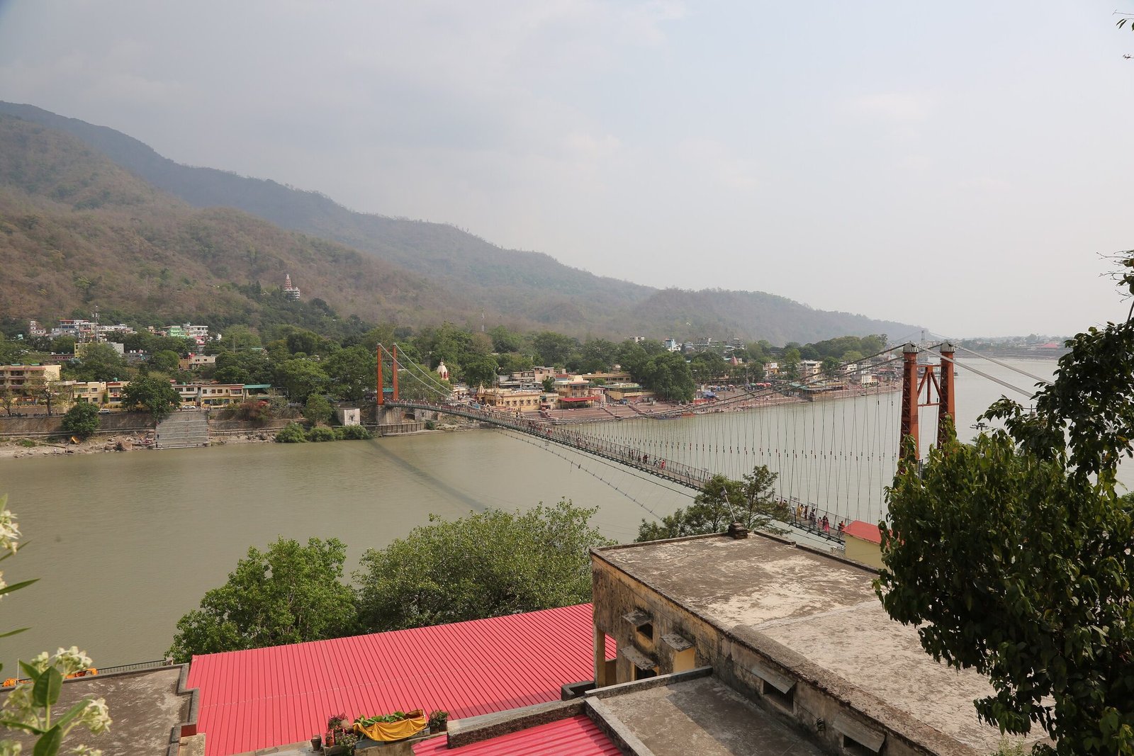 The Ram Jhula suspension bridge spanning the Ganges below the forested Himalayan foothills at Rishikesh
