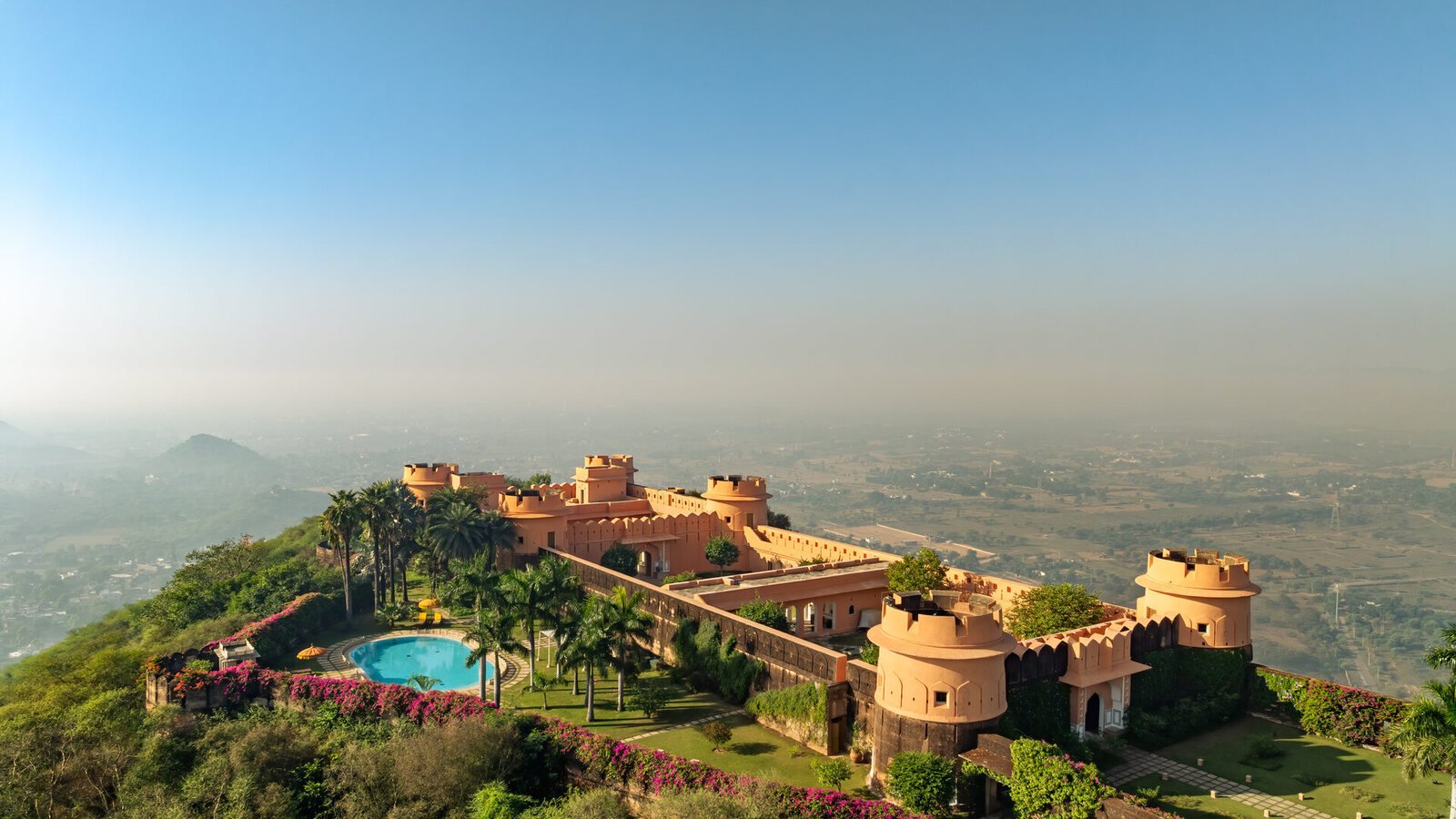 A luxury heritage fort-palace hotel crowning a hilltop above the Rajasthan plains